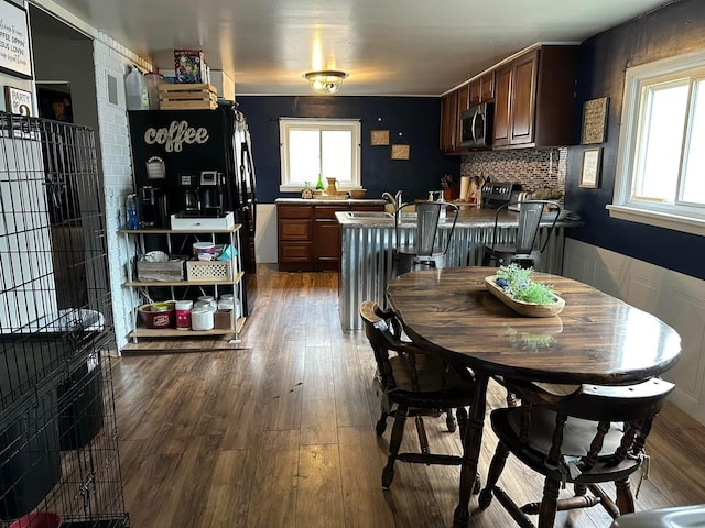 dining space with wainscoting and dark wood-style flooring