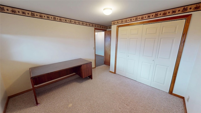 bedroom featuring a closet, light carpet, and baseboards