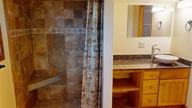 bathroom with tiled shower and vanity