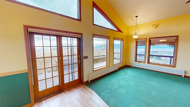 unfurnished sunroom with a baseboard heating unit and lofted ceiling