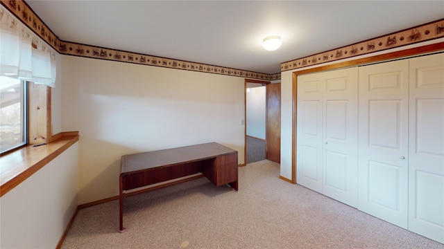 bedroom featuring a closet, baseboards, and light colored carpet