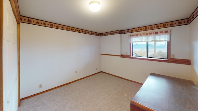 empty room featuring baseboards and carpet floors