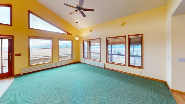 carpeted empty room featuring a baseboard heating unit, a healthy amount of sunlight, and ceiling fan