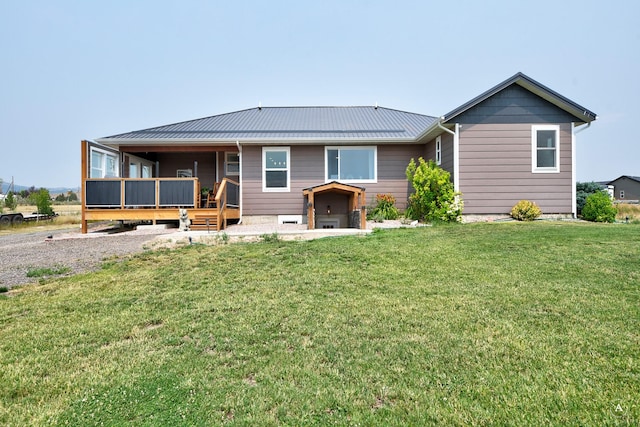 rear view of house featuring a lawn, metal roof, and a standing seam roof