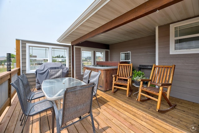 deck featuring outdoor dining area, grilling area, and a hot tub