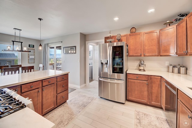 1825 Wooten Rd, Helena, MT 59602 - kitchen featuring stainless steel appliances, light countertops, pendant lighting, recessed lighting, and brown cabinets