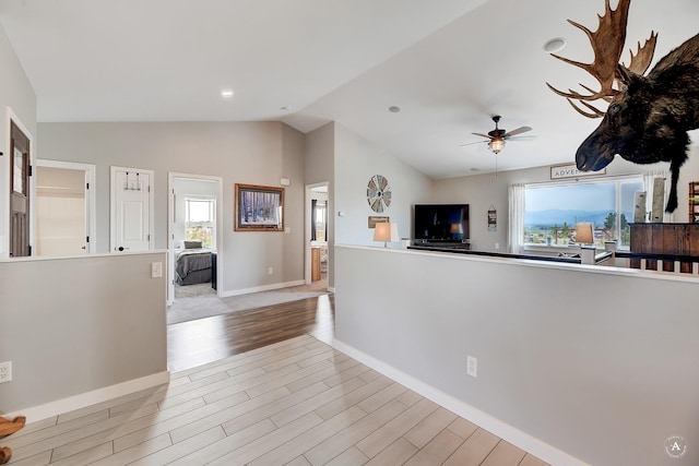 kitchen featuring baseboards, lofted ceiling, light wood-style flooring, and a ceiling fan