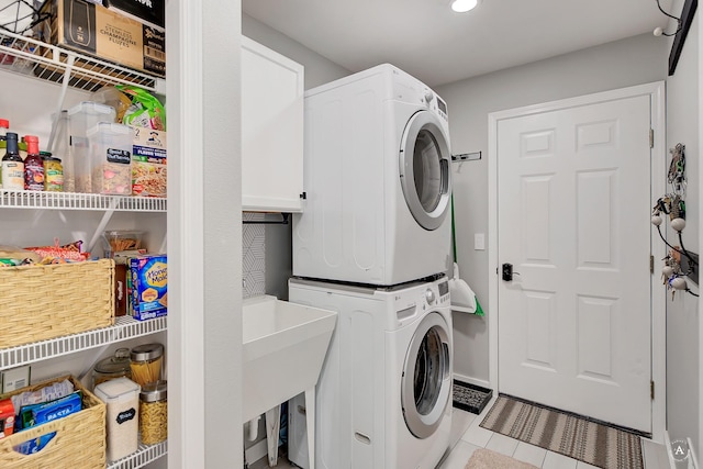 washroom featuring laundry area, stacked washer / dryer, and tile patterned floors