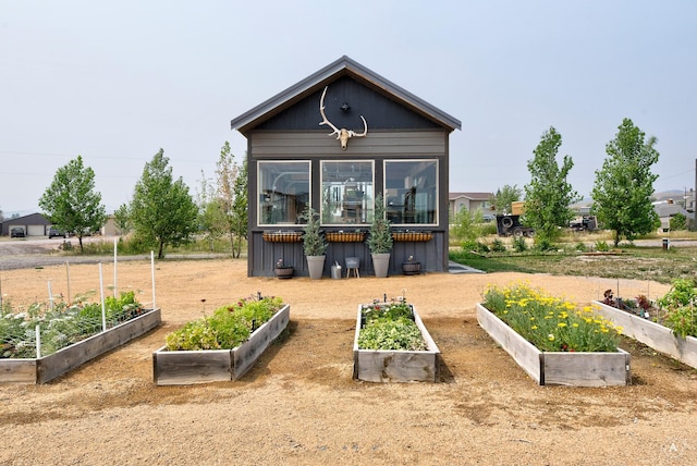 back of house featuring a vegetable garden