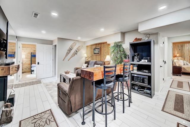 living area with recessed lighting, visible vents, and light wood-style floors