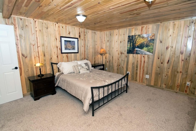 carpeted bedroom with wooden ceiling and wooden walls