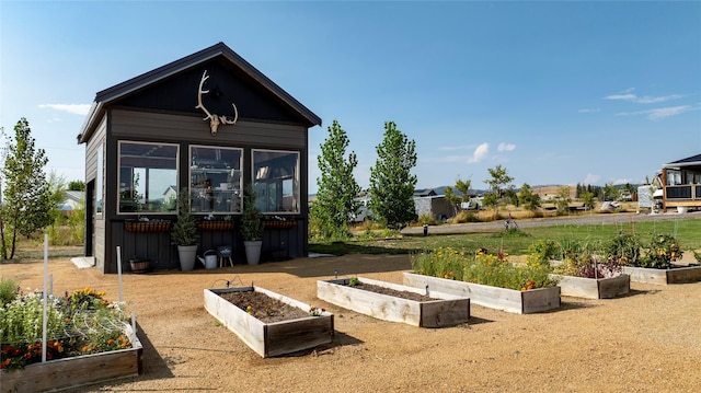 back of house with a vegetable garden