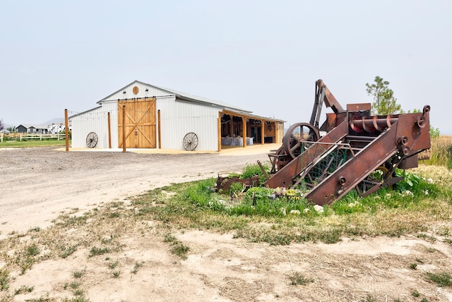 view of outbuilding featuring an outbuilding, an exterior structure, and driveway