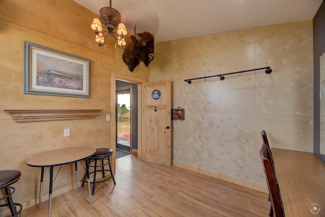 dining area featuring baseboards, an inviting chandelier, and wood finished floors