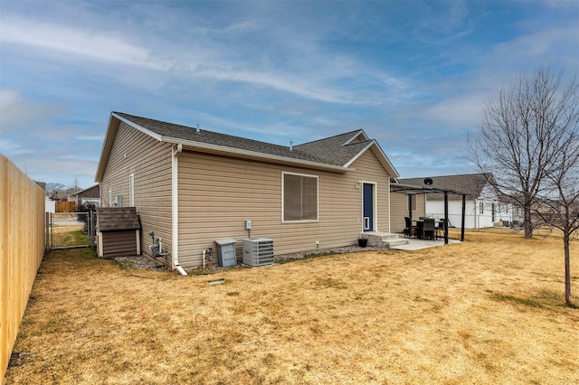 back of property with fence, central air condition unit, a lawn, a patio area, and a gate