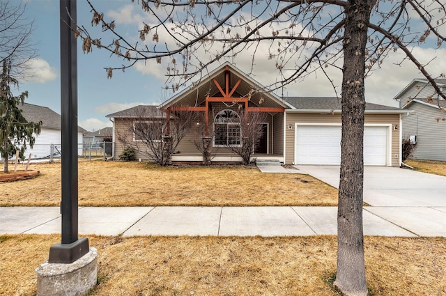 view of front of property with a garage, concrete driveway, a front yard, and fence