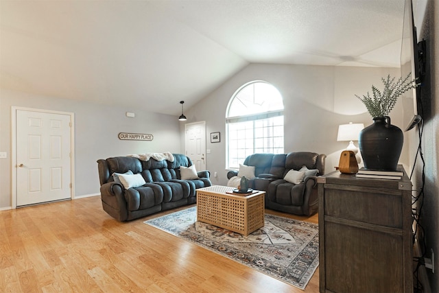 living area featuring baseboards, lofted ceiling, and light wood-style floors