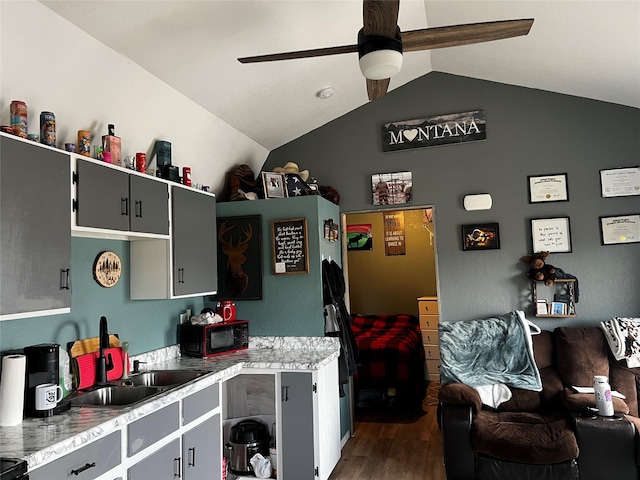 kitchen with light countertops, dark wood-style flooring, black microwave, and vaulted ceiling