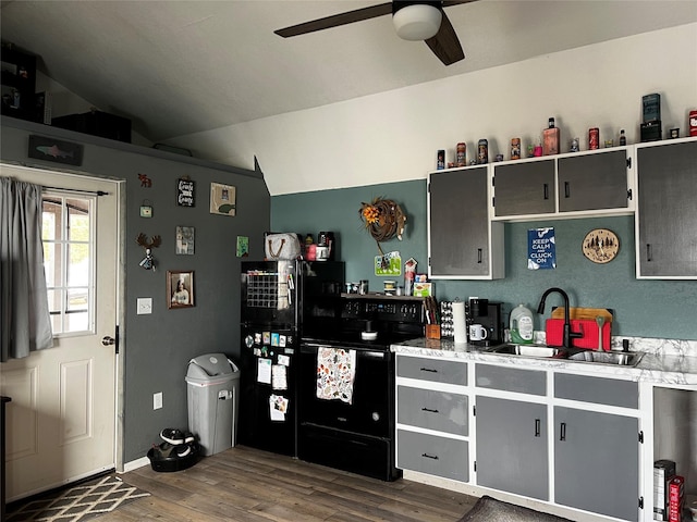 kitchen featuring lofted ceiling, gray cabinets, dark wood-style floors, electric range, and a sink