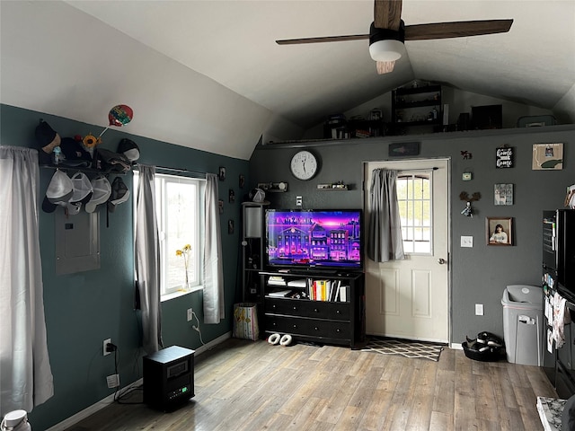 living area with ceiling fan, electric panel, wood finished floors, and vaulted ceiling