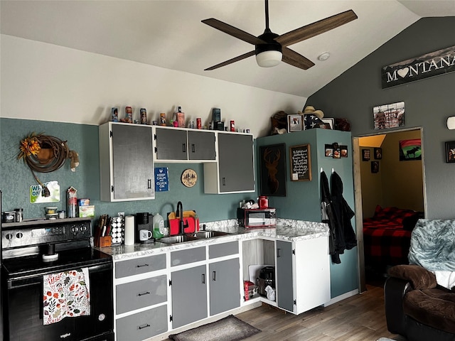 kitchen featuring black range with electric stovetop, ceiling fan, lofted ceiling, dark wood-style floors, and a sink