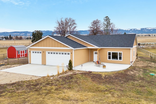 view of front of property featuring a mountain view, a garage, concrete driveway, and fence