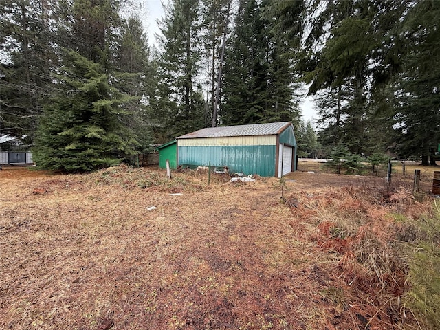 view of yard featuring a detached garage and an outbuilding