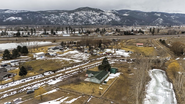 snowy aerial view with a rural view and a mountain view