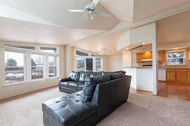 living room with lofted ceiling, light carpet, and ceiling fan