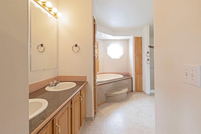 bathroom featuring double vanity, a bath, baseboards, and a sink