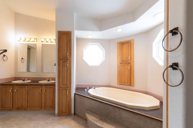 bathroom with double vanity, tile patterned floors, a garden tub, and a sink