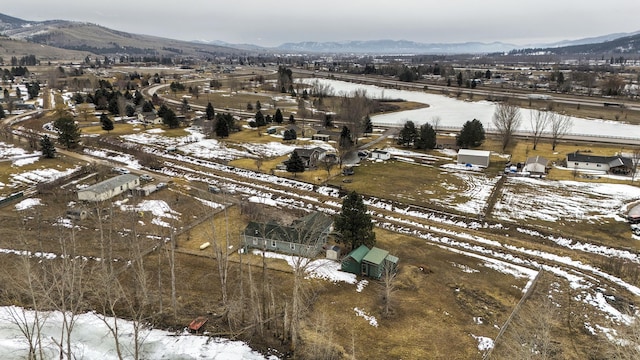 snowy aerial view featuring a rural view and a mountain view