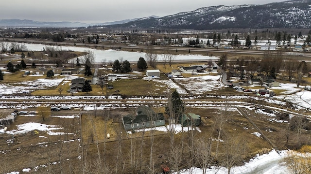 snowy aerial view featuring a mountain view and a rural view