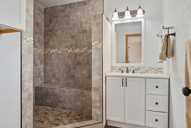 bathroom with tasteful backsplash, walk in shower, and vanity