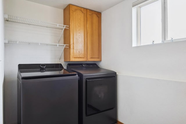 washroom with washer and clothes dryer and cabinet space