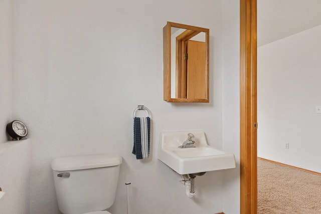 bathroom with a sink, baseboards, and toilet