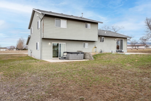 back of property with a patio area, a lawn, and a hot tub