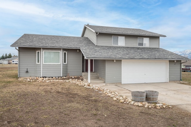 split level home featuring a garage, driveway, and a shingled roof