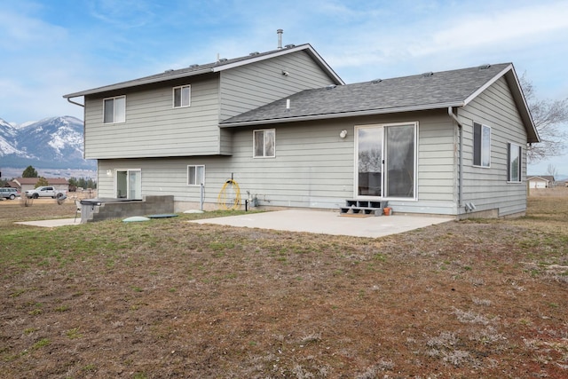 back of house featuring a yard, a patio area, and a mountain view