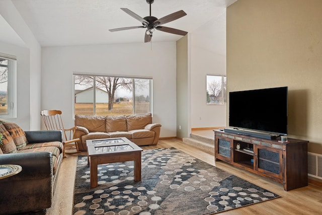 living area featuring ceiling fan, baseboards, lofted ceiling, and wood finished floors