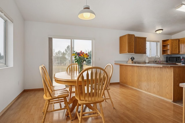 dining space featuring a wealth of natural light, baseboards, and light wood-style floors