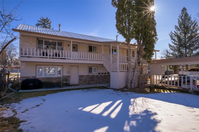 616 Madison St, Hamilton, MT 59840 - view of front of home featuring a metal roof, stone siding, a porch, and stairway