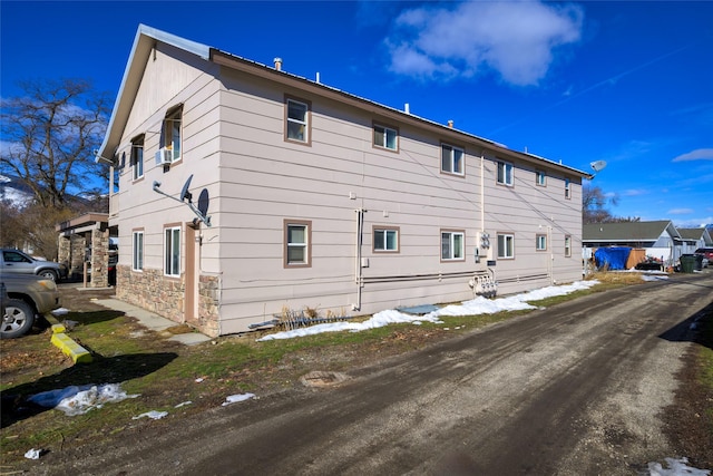 rear view of house featuring stone siding