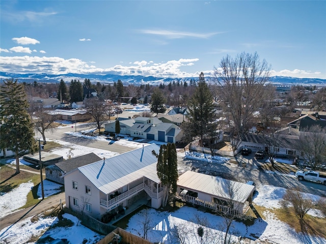 snowy aerial view featuring a residential view and a mountain view