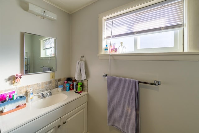 bathroom featuring backsplash, a healthy amount of sunlight, and vanity