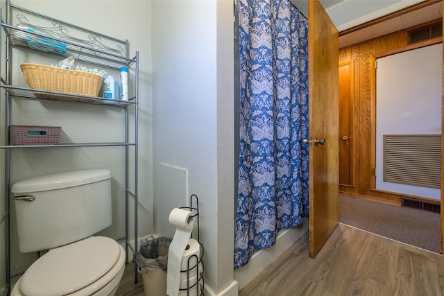 full bath featuring curtained shower, toilet, wood finished floors, and visible vents