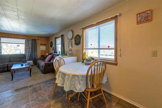 dining area with a wealth of natural light, stone finish flooring, and baseboards