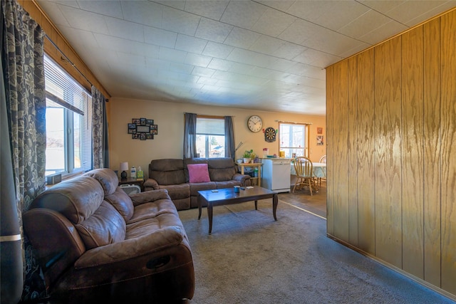 carpeted living area with wooden walls