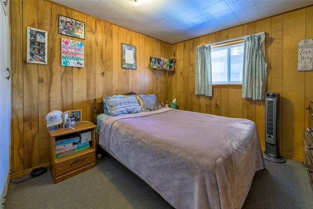 bedroom with carpet and wood walls