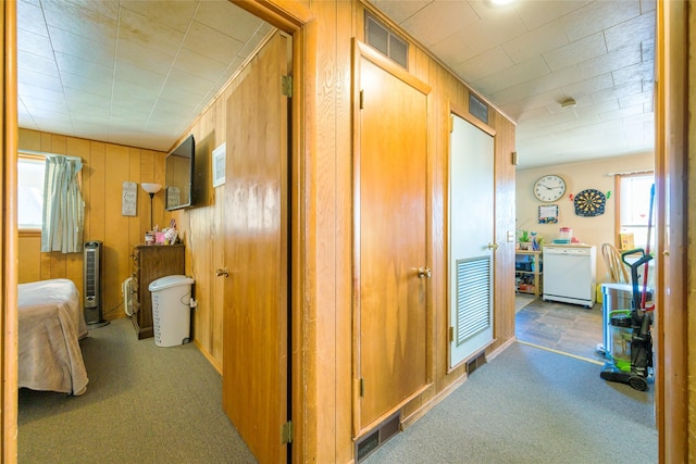 hall with carpet and visible vents